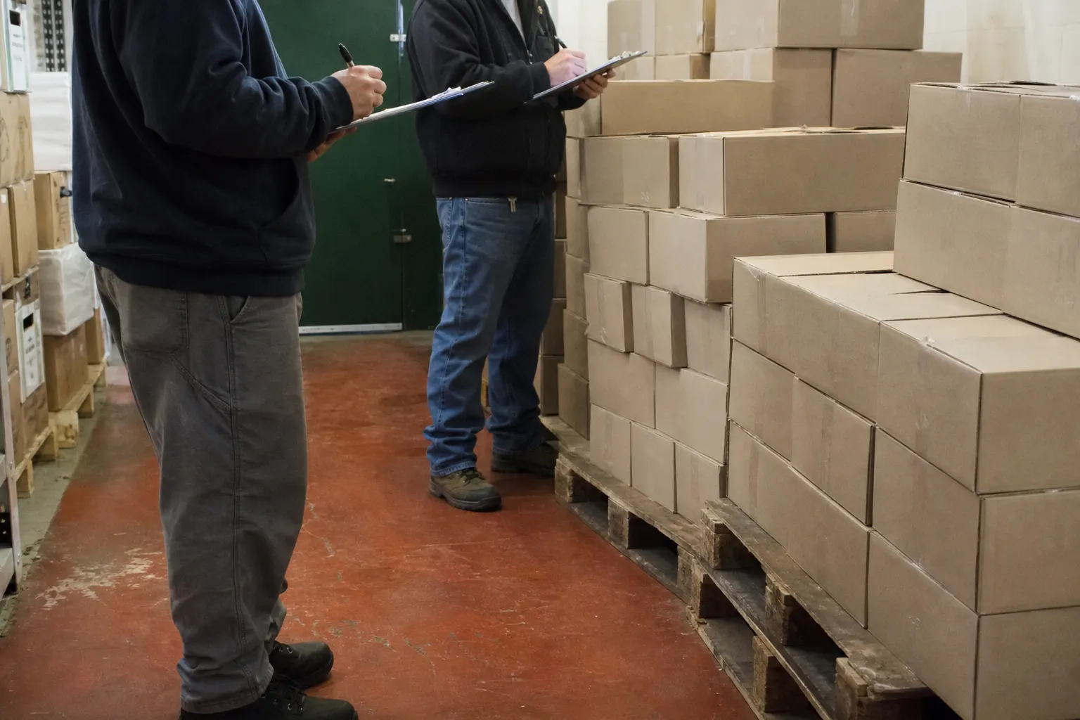 Clipboard inventory work in a grocery stockroom.